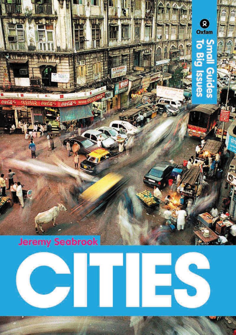 Aerial view of crowded Mumbai street with parked cars, vendors, pedestrians, and colonial architecture buildings.
