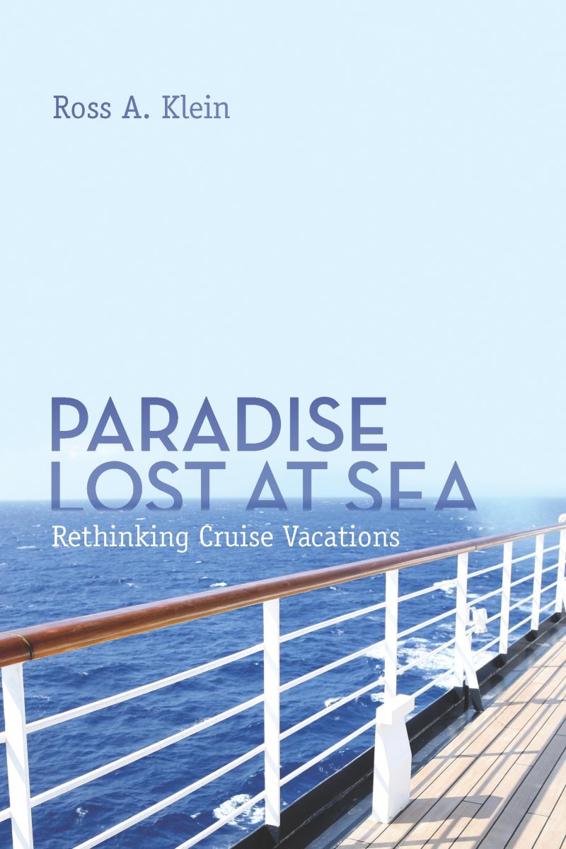 Cruise ship railing overlooking the ocean with clear blue water and sky in the background.