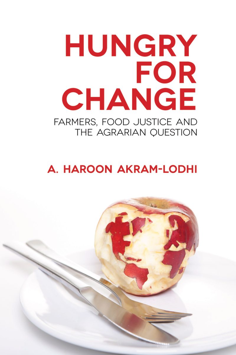 Book cover for "Hungry for Change" by A. Haroon Akram-Lodhi featuring an apple with a world map carved into it on a white plate with utensils.