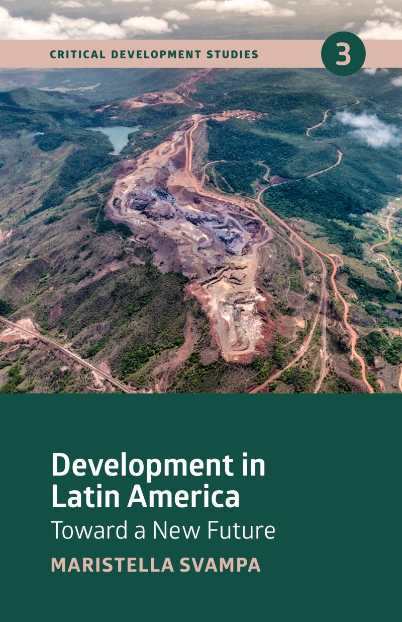 Aerial view of a large-scale mining or construction site carved into forested mountainous terrain with cleared land and winding roads.