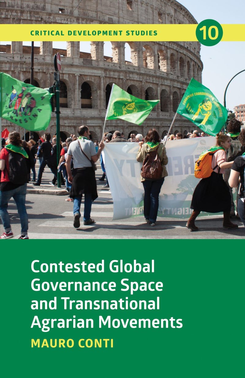 Activists with green flags protest in front of the Colosseum in Rome during a demonstration.