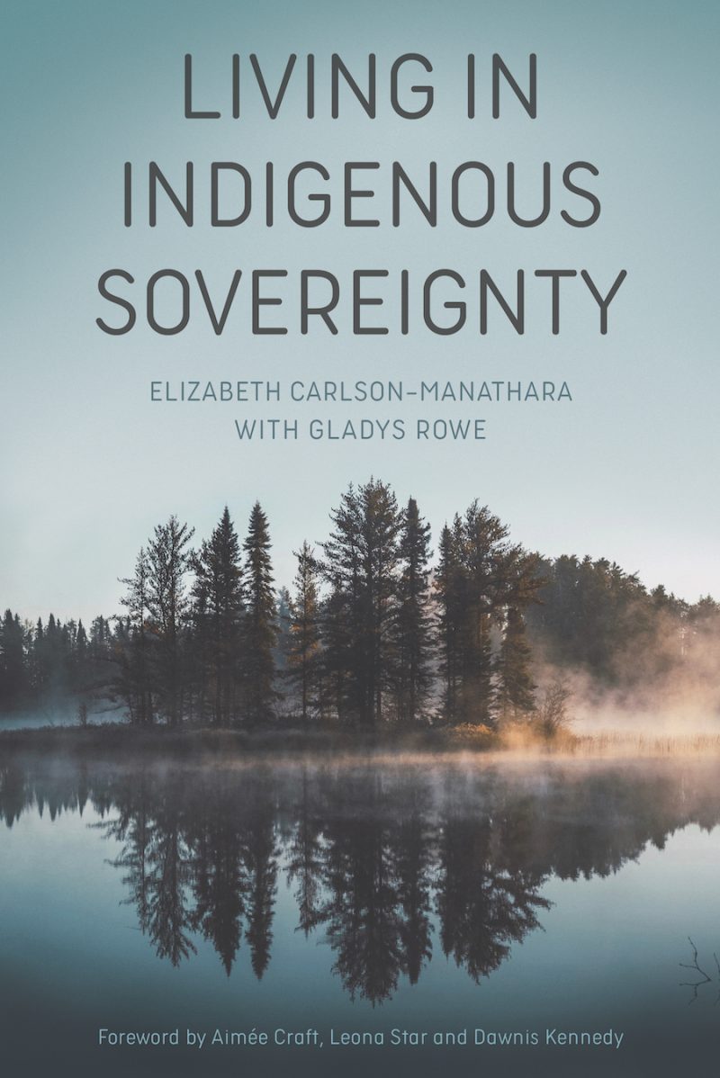 Book cover titled "Living in Indigenous Sovereignty" by Elizabeth Carlson-Manathara with Gladys Rowe, featuring a misty lake with forested shoreline at dawn.