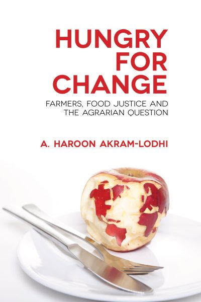 Book cover for "Hungry for Change" by A. Haroon Akram-Lodhi featuring an apple with a world map carved into it on a white plate with utensils.