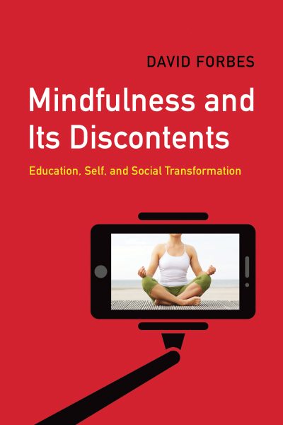 Book cover for "Mindfulness and Its Discontents" by David Forbes featuring a person in meditation pose displayed on a smartphone screen.