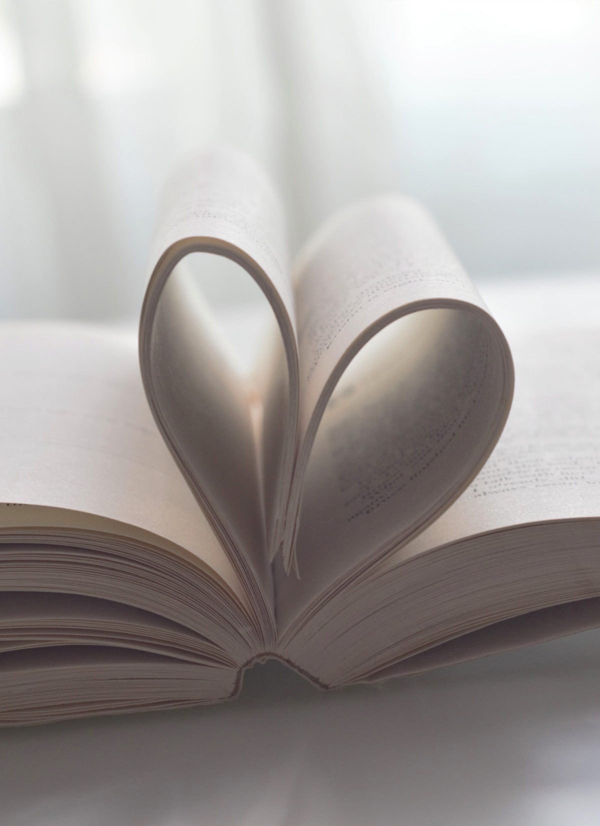 Open book with pages folded into a heart shape, symbolizing love of reading and literature.